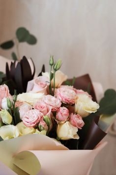 a bouquet of pink and white flowers with greenery