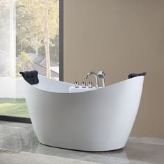 a white bath tub sitting on top of a tiled floor next to a window with lots of windows