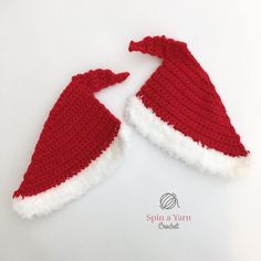 two red and white knitted santa hats sitting next to each other