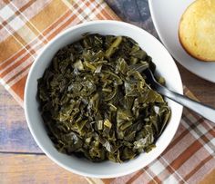 a white bowl filled with green tea next to a muffin on a wooden table