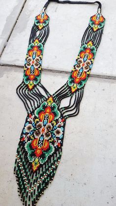 a multi - colored beaded necklace on a sidewalk