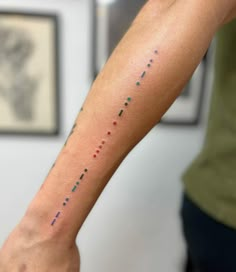 a person with a tattoo on their arm that has small dots all over the wrist