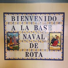 a tiled wall with pictures on it and words written in spanish above the toilet bowl