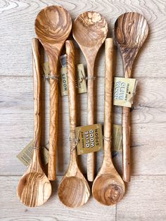 wooden spoons lined up on top of each other with price tags attached to them