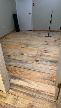 an empty room with hard wood floors and a mop on the floor next to it