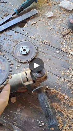 a person holding a drill in their hand while working on a piece of wood with other tools