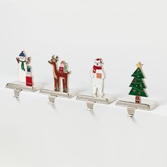 three metal christmas trees and two reindeers on top of each other in front of a white background