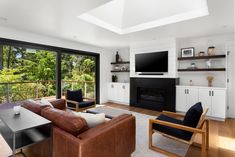 a living room filled with furniture and a flat screen tv mounted on the wall above a fireplace