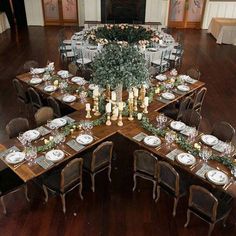 a dining room table set up with place settings and centerpieces for an elegant dinner