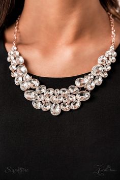 a woman wearing a black shirt and a necklace with crystal stones on it's neck