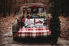 an old pickup truck with christmas decorations on the bed and plaid blanket in the back