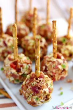 small appetizers with toothpicks are on a white tray and ready to be eaten