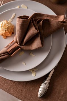 a white plate topped with a brown napkin and two desserts on top of it