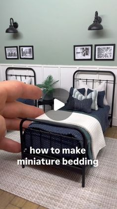 a person is pointing at a miniature bed