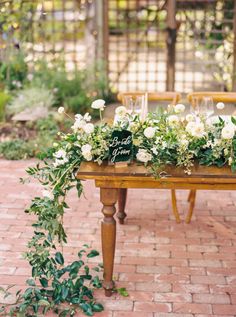 a table with flowers and greenery on it