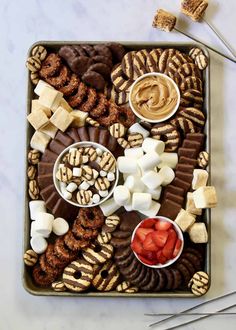 a platter filled with cookies, marshmallows, strawberries and pretzels