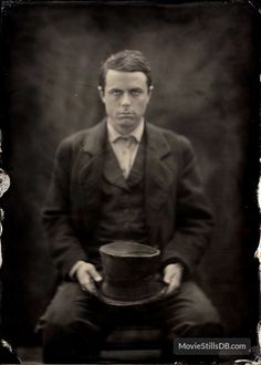 an old photo of a man holding a top hat