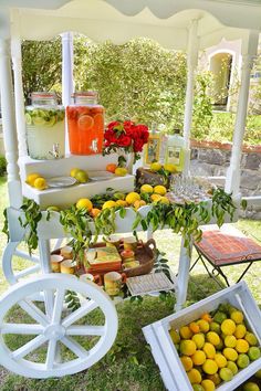 lemons, oranges and other fruit are on display in front of a white cart