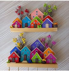 two wooden shelves with colorful houses on them and flowers in the middle one shelf is made out of wood