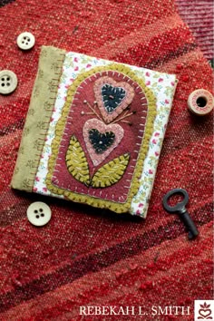 a book with buttons on it sitting next to a pair of scissors and some thread