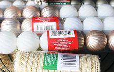 several rolls of twine wrapped with white and silver balls in a store display case