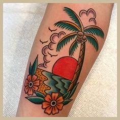 a colorful tattoo with flowers and a palm tree