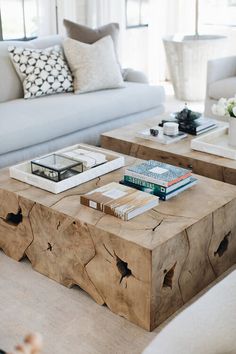 two wooden tables with books on them in front of a couch and coffee table next to each other