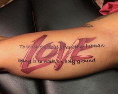 a woman's arm with the words love tattooed on it