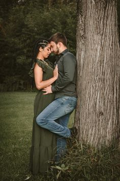 a man and woman embracing in front of a tree