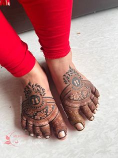 a woman's feet with henna tattoos on them