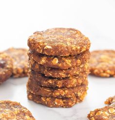 a stack of cookies sitting on top of a white table next to other cookies and nuts