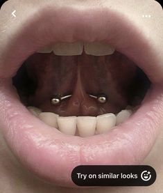 a woman's mouth with two piercings on it