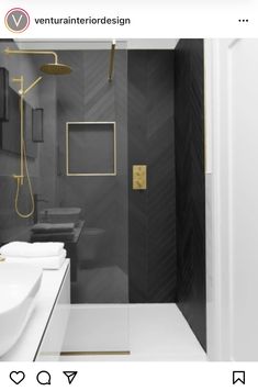 a bathroom with black and white walls, gold trimmings and a walk in shower