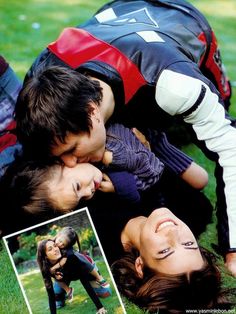 a group of people laying on top of each other in the grass with their heads together