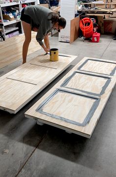 a woman is working on some wood pieces