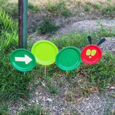 four frisbees are arranged in the shape of caterpillars and an arrow