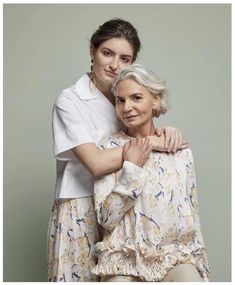 two older women hugging each other in front of a gray background with the caption's photo