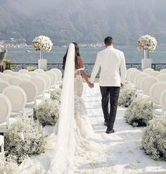 a bride and groom walking down the aisle at their wedding ceremony in front of an ocean view