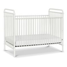 a white crib with no mattress in the front and side rails on each side