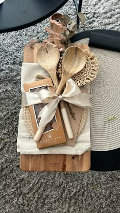 wooden utensils wrapped in white ribbon on top of a table with other items