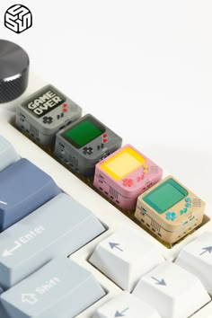 a keyboard with four different colored game controllers on it's keys and an object next to it