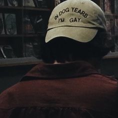 a man wearing a hat that says no dog years i'm gay