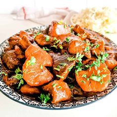 a plate with meat and carrots covered in sauce