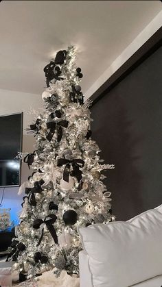 a white christmas tree with black and silver decorations