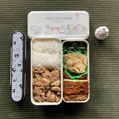 a bento box filled with rice, meat and veggies next to a toy