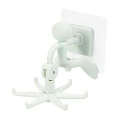 a white plastic figurine is attached to a wall mounted light switch with two arms and legs