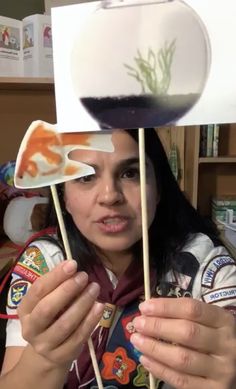 a woman holding up some food on sticks