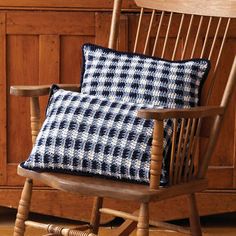 a wooden rocking chair with a blue and white pillow on it