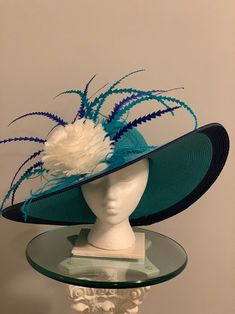 WAS $165  NOW $95 Ocean blue hat with royal blue brim. White feathered centered accent "flower of feathers." Various colored blue zigzag cut rooster feathers complete the elegant look. Blue Hat With Feather Trim For Spring, Blue Feather Trim Hat For Kentucky Derby, Blue Summer Hat With Feathers, Adjustable Blue Hat With Feather Trim, Blue Pre-shrunk Hat With Curved Brim, Wide Brimmed Hat, Rooster Feathers, Brimmed Hat, Discount Sale