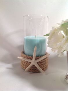 a glass vase with a starfish on it next to a candle